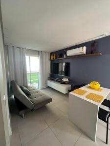 ein Wohnzimmer mit einem Sofa und einem Tisch in der Unterkunft Flatsportojjp - Flat Cupe Beach in Porto De Galinhas