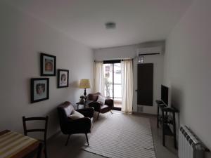 een woonkamer met twee stoelen en een tv bij Departamento boutique en Salta in Salta