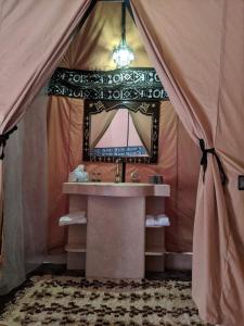 een badkamer met een wastafel en een spiegel bij camp erg chebbi luxury in Merzouga