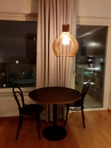 a table with two chairs and a lamp next to a window at Two room Apartment in Sundbyberg Stockholm in Sundbyberg