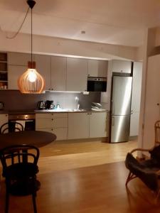 a kitchen with a table and a stainless steel refrigerator at Two room Apartment in Sundbyberg Stockholm in Sundbyberg