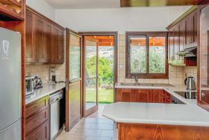 a kitchen with wooden cabinets and a white counter top at Villa Aphrodite in Argaka