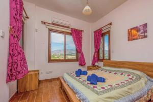 a bedroom with a large bed with purple curtains at Villa Aphrodite in Argaka