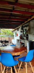 una sala da pranzo con tavolo in legno e sedie blu di QUINTAS DA BARRA BNB a 30m da praia a Balneário Barra do Sul