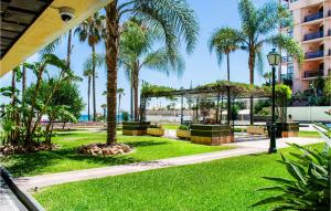 a park with palm trees and a building at Cozy Apartment In Torremolinos With Wifi in Torremolinos