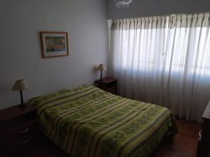 1 dormitorio con 1 cama y una ventana con cortinas en Departamento en Mar del Plata, excelente ubicación, pleno centro, 3 habitaciones. en Mar del Plata