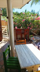 Piriápolis Corralejo في بيريابوليس: طاولة وكراسي خشبية على فناء به زهور
