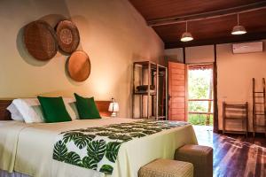 um quarto com uma cama grande e almofadas verdes em Glamping Mangarito em Iporanga