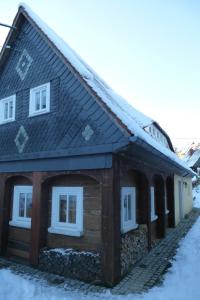 een houten huis met sneeuw op het dak bij Ferienhaus Waltersdorf in Großschönau