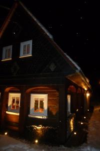 a house with lights in the windows at night at Ferienhaus Waltersdorf in Großschönau