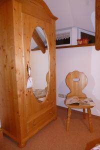 グロースシェーナウにあるFerienhaus Waltersdorfの鏡と椅子付きの木造の部屋