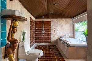 a bathroom with a toilet and a tub and a sink at Panviman Resort Koh Phangan - SHA Extra Plus in Thong Nai Pan Noi