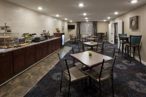 ein Restaurant mit Tischen und Stühlen und eine Küche in der Unterkunft GrandStay Hotel & Suites - Glenwood in Glenwood
