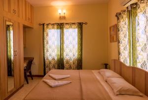 a bedroom with a large bed and a window at Dona Paula Apartment in Dona Paula