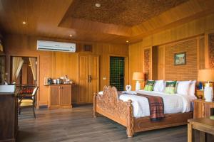 a bedroom with a large bed with wooden walls at Panviman Resort Koh Phangan - SHA Extra Plus in Thong Nai Pan Noi