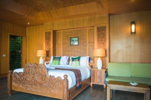 a bedroom with a large bed and a couch at Panviman Resort Koh Phangan - SHA Extra Plus in Thong Nai Pan Noi