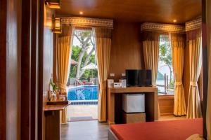 a living room with yellow curtains and a large window at Panviman Resort Koh Phangan - SHA Extra Plus in Thong Nai Pan Noi
