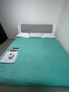 Apartamento en santa marta donde jesus 2 في سانتا مارتا: سرير مع مرتبة خضراء عليها صينية