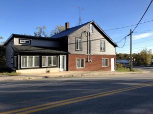 a house on the side of a street with a road at La cachette de la rivière au saumon et spa in Scotstown