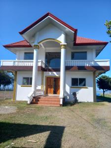 ein weißes Haus mit rotem Dach in der Unterkunft Seven Waves Beachfront Vacation Home, Bauang La Union 