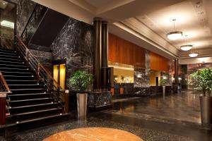a lobby of a hotel with stairs and potted plants at Millennium Hotel Broadway Times Square in New York