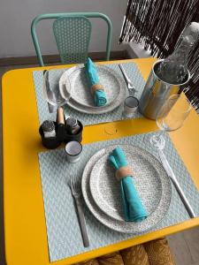 une table jaune avec des assiettes et des ustensiles dans l'établissement T2 Saint-Denis -Jardin de l'Etat, à Saint-Denis