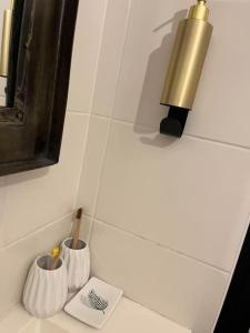 Un mostrador de baño con dos tazas y un cepillo de dientes. en T2 Saint-Denis -Jardin de l'Etat, en Saint-Denis