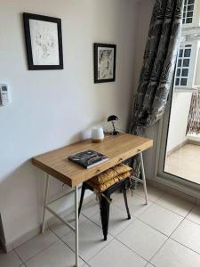 a wooden desk in a room with a window at T2 Saint-Denis -Jardin de l'Etat in Saint-Denis