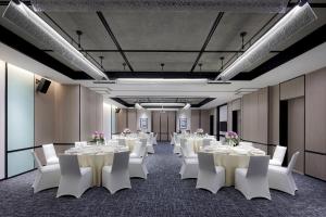 深セン市にあるFour Points by Sheraton Shenzhen Bao'anの白いテーブルと白い椅子が備わる会議室