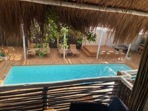 ein Pool mit einem Strohschirm und ein Resort in der Unterkunft NENA BEACH CLUB & HOTEL in Barú