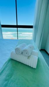 um quarto com três toalhas numa cama com uma janela em Rudá Boutique Hotel Porto de Galinhas em Porto de Galinhas