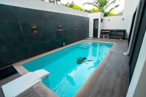 una piscina con una persona in acqua di Casa Moderna de 4 Pisos Con Rooftop Vista Al Mar a Isla Mujeres