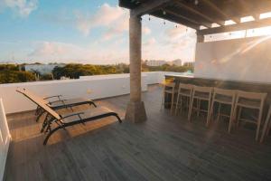 patio con sedie e bar sul tetto di Casa Moderna de 4 Pisos Con Rooftop Vista Al Mar a Isla Mujeres