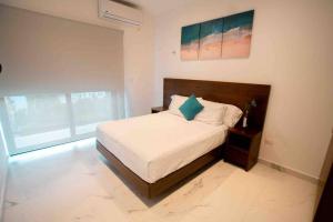 una camera da letto con un letto con un cuscino blu di Casa Moderna de 4 Pisos Con Rooftop Vista Al Mar a Isla Mujeres Altre 31 foto