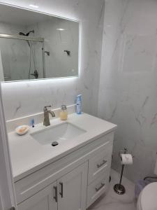 bagno bianco con lavandino e specchio di 3509 Luxury Location and Location a Orlando