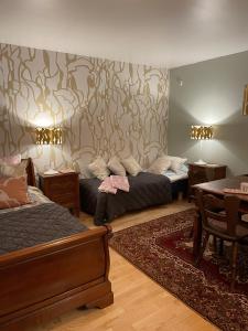 ナーンタリにあるSininen Taloのベッド2台、テーブル、ソファが備わる客室です。