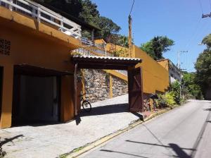 una bicicletta parcheggiata accanto a un edificio su una strada di Por de sol no mar da cama a Caraguatatuba