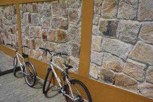 2 biciclette parcheggiate accanto a un muro di pietra di Por de sol no mar da cama a Caraguatatuba