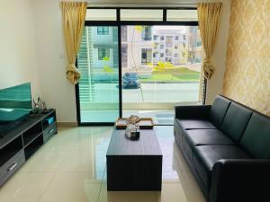 a living room with a black couch and a large window at The Meadow Park 4R4B in Kampar