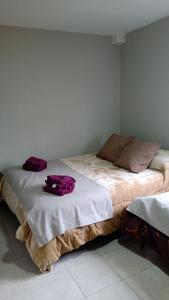 a bedroom with a bed with purple clothes on it at Calido alojamiento in Ushuaia