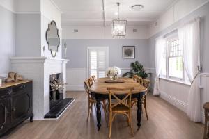 a dining room with a table and a fireplace at River Hamptons in Berri