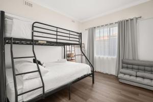 1 Schlafzimmer mit 2 Etagenbetten und einem Fenster in der Unterkunft Coronet Spa Retreat in Corinella