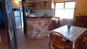 a kitchen with a table and a kitchen with a refrigerator at Agua Corazones in San Luis