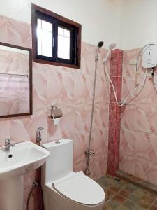 a bathroom with a shower and a toilet and a sink at Woodland Inn in El Nido