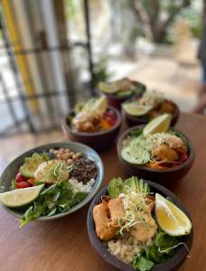 a group of bowls of food on a wooden table at Tanah Loft - in Villa Mercedes