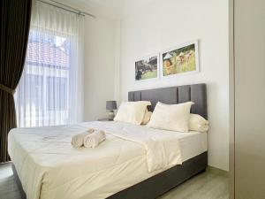 a bedroom with a large bed with towels on it at De Residence Pangandaran by Mabano Estates in Pangandaran
