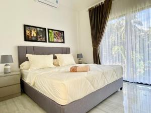 Postel nebo postele na pokoji v ubytování De Residence Pangandaran by Mabano Estates