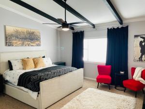 a bedroom with a bed and two red chairs at Sandstone Ridge Apartments Remodeled 6 Bedroom 4 Bath in Oklahoma City