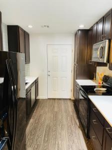 a kitchen with wooden cabinets and a white door at Sandstone Ridge Apartments Remodeled 6 Bedroom 4 Bath in Oklahoma City