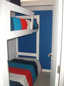 a bedroom with two bunk beds with blue walls at Troia in Troia